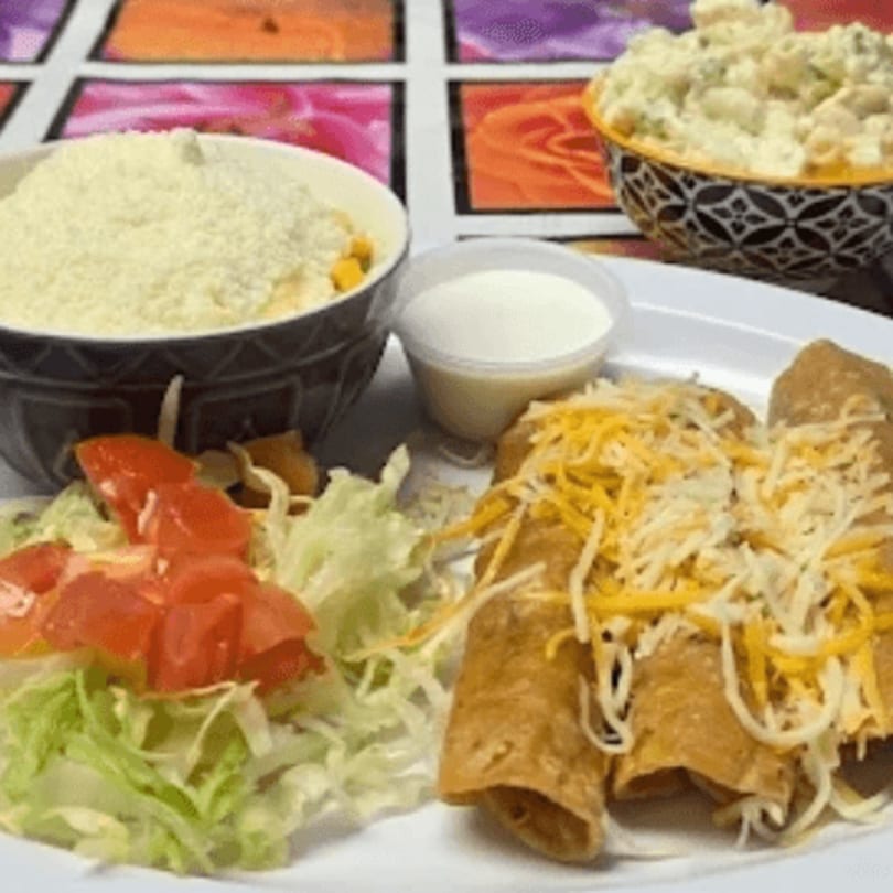 Latin Bliss enchiladas with shredded cheese, a side salad, rice, and macaroni salad.